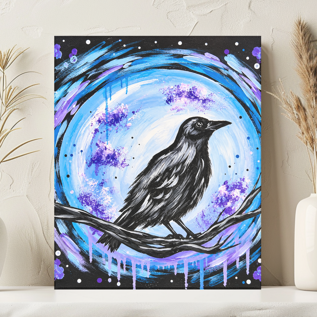 A vertical art print featuring a black raven perched on a branch in front of a glowing blue and purple moon, displayed on a shelf between two white vases with dried grass.