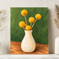 A vertical canvas art print depicting yellow globes on a wooden table in a cream-colored vase against a textured green background, styled on a white surface between two white vases with dried grass.
